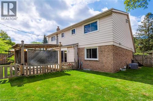 Expansive lawn area, brick veneer lower level, siding upper level, and a wooden deck with pergola - 4248 Dunvegan Road, Burlington, ON 