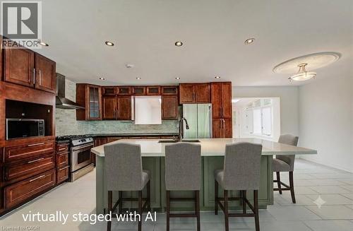 Kitchen featuring wood cabinetry, stainless steel appliances, a center island with countertop seating, recessed lighting, and tile flooring - 109 White Oak Place, Waterloo, ON - Indoor
