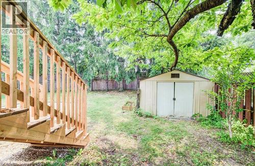 Expansive outdoor space featuring a new wood deck, mature trees, a storage shed, and a wood fence - 109 White Oak Place, Waterloo, ON - Outdoor