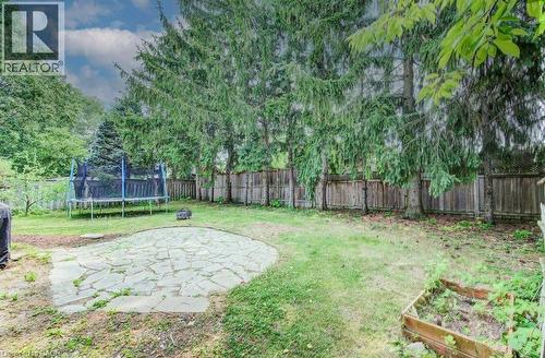 Expansive backyard featuring a natural stone patio and mature trees - 109 White Oak Place, Waterloo, ON - Outdoor
