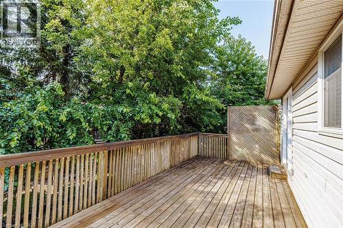 Spacious outdoor deck with natural wood railing, wood-plank flooring, and privacy lattice - 47 Queensway Drive, Strathroy, ON - Outdoor With Deck Patio Veranda