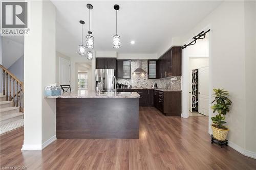 Kitchen featuring dark wood cabinetry, stainless steel appliances, and a mosaic tile backsplash - 57 Cheevers Road, Brantford, ON - Indoor Photo Showing Kitchen With Upgraded Kitchen