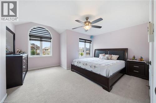 Arched window with integrated blinds, vaulted ceiling, ceiling fan with illumination, and plush carpet flooring - 57 Cheevers Road, Brantford, ON - Indoor Photo Showing Bedroom