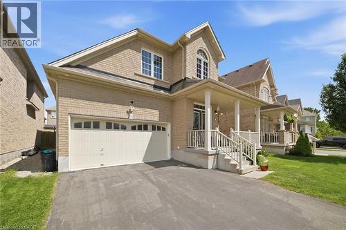 Brick exterior with a covered front porch featuring white railings and columns - 57 Cheevers Road, Brantford, ON - Outdoor