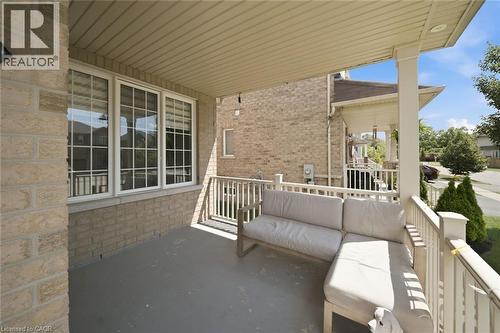 Covered front porch featuring a light brick exterior and white railing - 57 Cheevers Road, Brantford, ON - Outdoor With Exterior