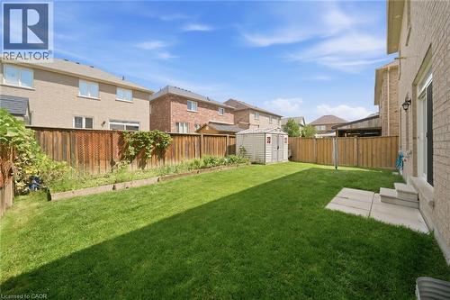 Expansive lawn area, raised garden beds, wood fencing, and a storage shed - 57 Cheevers Road, Brantford, ON - Outdoor