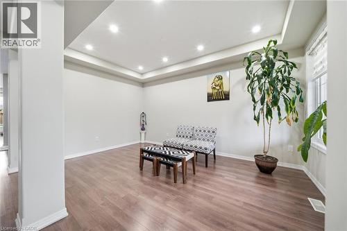 Tray ceiling with recessed lighting, wood-finish flooring, and white trim - 57 Cheevers Road, Brantford, ON - Indoor Photo Showing Other Room