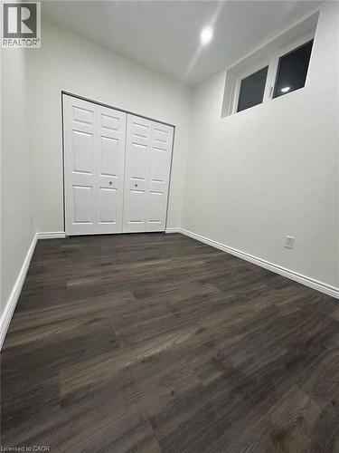 Wood-finish flooring, white walls, bi-fold closet doors, high-set window, recessed ceiling lighting - 31 Sofitel Drive, Kitchener, ON - Indoor Photo Showing Other Room
