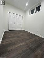 Wood-finish flooring, white walls, bi-fold closet doors, high-set window, recessed ceiling lighting - 