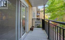 Private balcony with patterned flooring, black metal railings, and a sliding glass door - 