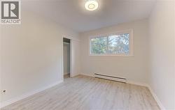 Wood-finish flooring, white walls, built-in closet with sliding doors, and a double window - 