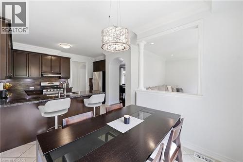 Kitchen featuring dark wood cabinetry, a built-in stainless steel range, and a breakfast bar with stone countertops - 738 Fourth Line, Milton, ON - Indoor Photo Showing Dining Room