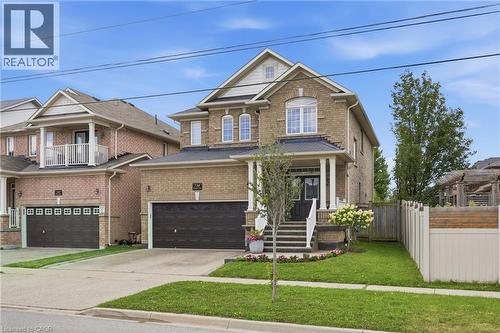 Brick exterior with a covered porch entry, white columns, and dark trim - 738 Fourth Line, Milton, ON - Outdoor With Facade