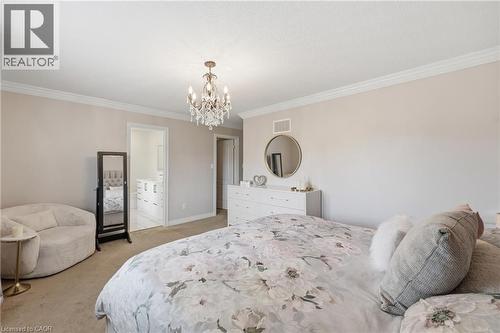 Crowning chandelier, light-toned walls, and soft carpet flooring - 738 Fourth Line, Milton, ON - Indoor Photo Showing Bedroom
