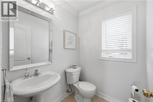 Pedestal sink with chrome faucet, beveled mirror, and wall-mounted light fixture - 738 Fourth Line, Milton, ON - Indoor Photo Showing Bathroom