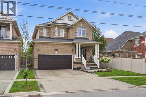 Brick exterior with a covered front porch featuring white columns and railings - 738 Fourth Line, Milton, ON - Outdoor With Facade