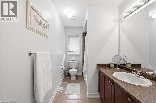 Vanity with an integrated sink, brown wood-finish cabinetry, and a full-width mirror - 738 Fourth Line, Milton, ON - Indoor Photo Showing Bathroom