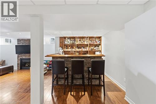 Stone-clad bar with wood countertop and open shelving - 738 Fourth Line, Milton, ON - Indoor