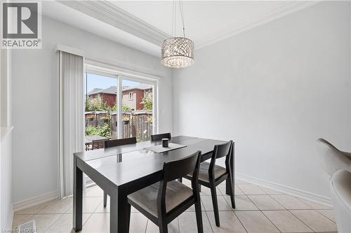 Sliding glass door leading to the exterior, crown molding, tile flooring, and a decorative pendant light fixture - 738 Fourth Line, Milton, ON - Indoor Photo Showing Dining Room
