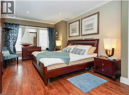 Hardwood flooring, recessed ceiling lighting, crown molding, double window with blinds, and built-in bedside table - 453 Brant Street, Burlington, ON 
