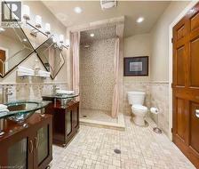 Dual glass vessel sinks with wood-finish vanities, a mosaic tile shower, and patterned floor tiles - 