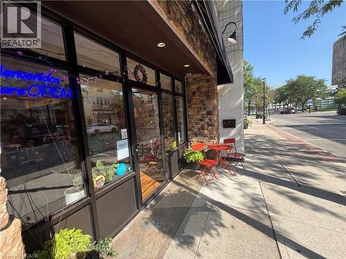 Stone facade with dark-framed storefront windows and a dark awning - 453 Brant Street, Burlington, ON 