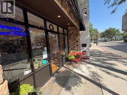 Stone facade with dark-framed storefront windows and a dark awning - 