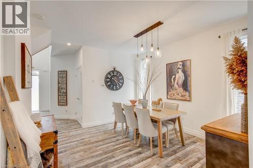 Spacious dining area featuring wood-finish flooring, a linear pendant light fixture, and recessed lighting - 1061 Eagletrace Drive Unit# 174, London, ON - Indoor Photo Showing Dining Room