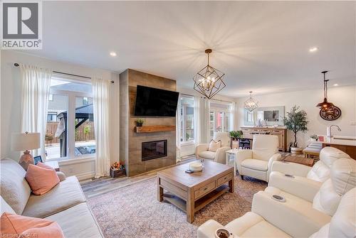 Recessed lighting, wood-finish flooring, and a tiled fireplace surround - 1061 Eagletrace Drive Unit# 174, London, ON - Indoor Photo Showing Living Room With Fireplace