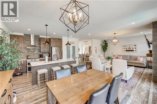 Open-concept living space with wood-finish flooring, recessed lighting, and geometric light fixtures - 1061 Eagletrace Drive Unit# 174, London, ON - Indoor