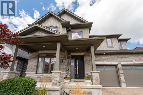 Brick and stone facade with a covered porch, multiple gables, and an integrated two-car garage - 1061 Eagletrace Drive Unit# 174, London, ON - Outdoor With Facade