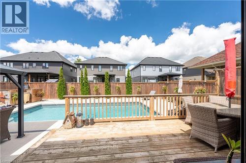 Expansive wood-finish deck with a built-in swimming pool - 1061 Eagletrace Drive Unit# 174, London, ON - Outdoor With In Ground Pool With Deck Patio Veranda