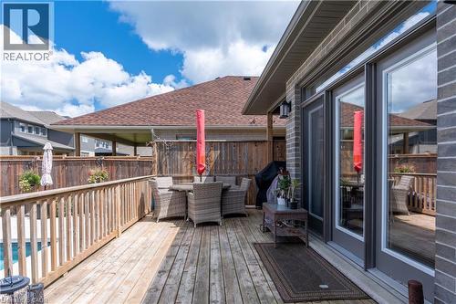 Expansive wooden deck with a built-in privacy fence, featuring direct access to the interior via glass doors and an exterior light fixture - 1061 Eagletrace Drive Unit# 174, London, ON - Outdoor With Deck Patio Veranda With Exterior