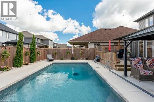 In-ground swimming pool with surrounding concrete patio - 1061 Eagletrace Drive Unit# 174, London, ON - Outdoor With In Ground Pool With Deck Patio Veranda
