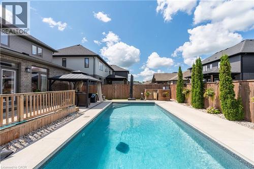In-ground swimming pool with surrounding concrete hardscaping - 1061 Eagletrace Drive Unit# 174, London, ON - Outdoor With In Ground Pool With Deck Patio Veranda