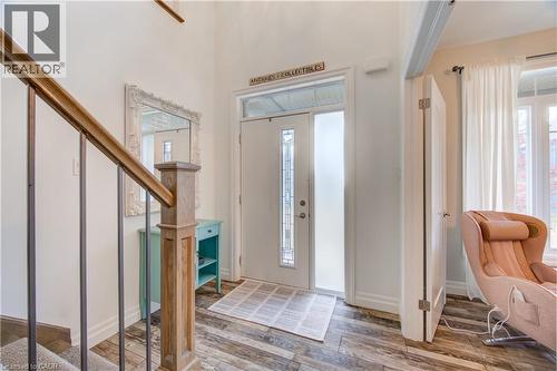 Entryway featuring wood-finish flooring, a white paneled door with decorative glass inserts, and a high ceiling - 1061 Eagletrace Drive Unit# 174, London, ON - Indoor Photo Showing Other Room