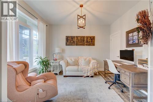 Wall-mounted lighting fixture, light-toned walls, wood-finish flooring, and a window with white trim - 1061 Eagletrace Drive Unit# 174, London, ON - Indoor
