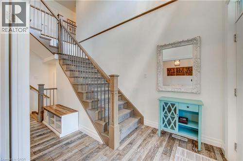 Wood-finish flooring, staircase with wood newel posts, wrought iron balusters, and carpeted treads - 1061 Eagletrace Drive Unit# 174, London, ON - Indoor Photo Showing Other Room