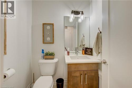 Vanity with wood-finish cabinetry, integrated sink, and light-toned countertop - 1061 Eagletrace Drive Unit# 174, London, ON - Indoor Photo Showing Bathroom