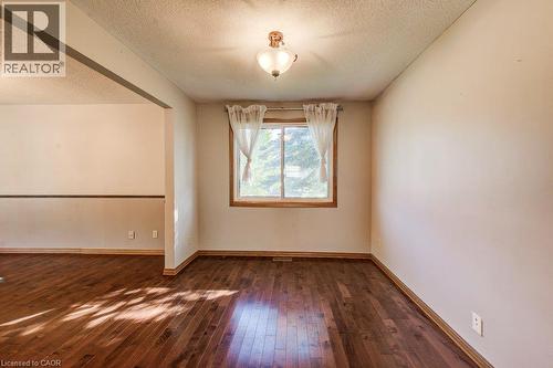 Wood-finish flooring, overhead lighting fixture, and a window with wood trim - 3 Cora Drive, Kitchener, ON - Indoor Photo Showing Other Room