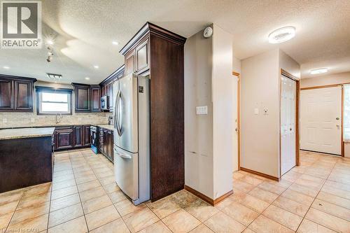 Kitchen featuring dark wood cabinetry, granite countertops, and stainless steel appliances - 3 Cora Drive, Kitchener, ON - Indoor Photo Showing Kitchen