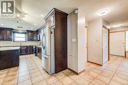 Kitchen featuring dark wood cabinetry, granite countertops, and stainless steel appliances - 