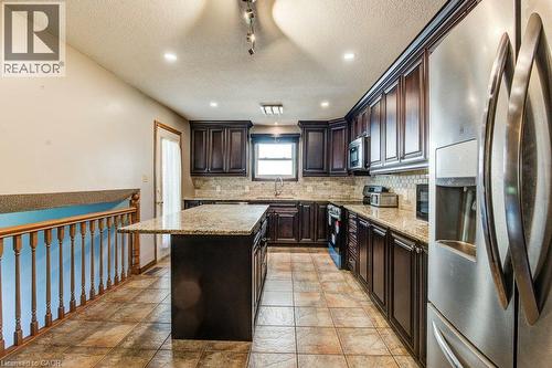 Kitchen featuring dark wood cabinetry, light-toned countertops, stainless steel appliances, and tile flooring - 3 Cora Drive, Kitchener, ON - Indoor Photo Showing Kitchen With Double Sink With Upgraded Kitchen