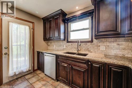 Dark wood cabinetry, granite countertops, dual basin sink with gooseneck faucet, stainless steel dishwasher, and tile flooring - 3 Cora Drive, Kitchener, ON - Indoor Photo Showing Kitchen With Double Sink