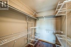 Closet with extensive wire shelving, multiple hanging rods, and wood-finish flooring - 