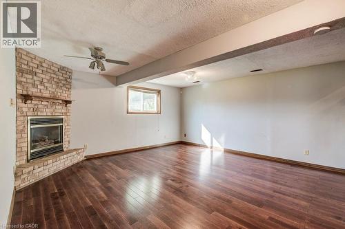Hardwood flooring throughout, a brick-clad fireplace, and a ceiling fan - 3 Cora Drive, Kitchener, ON - Indoor With Fireplace