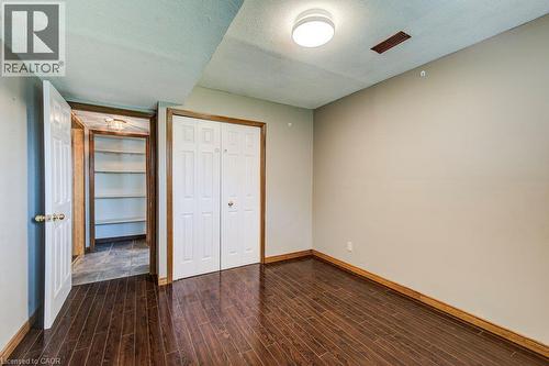 Rich wood-finish flooring, neutral wall tones, bi-fold closet doors, and recessed ceiling lighting - 3 Cora Drive, Kitchener, ON - Indoor Photo Showing Other Room