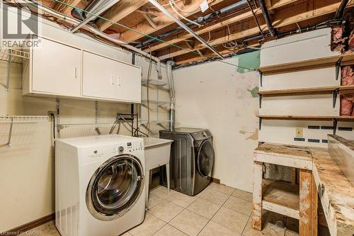 Laundry area with tiled flooring, overhead cabinetry, and built-in shelving - 3 Cora Drive, Kitchener, ON - Indoor Photo Showing Laundry Room