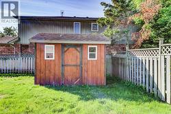 Wood-sided storage shed with a shingle roof and two windows - 