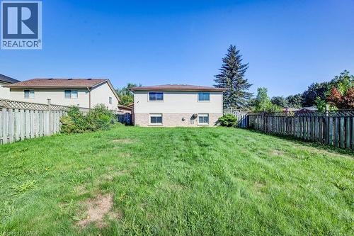Expansive rear yard with a sloped lawn, bordered by wood fencing - 3 Cora Drive, Kitchener, ON - Outdoor